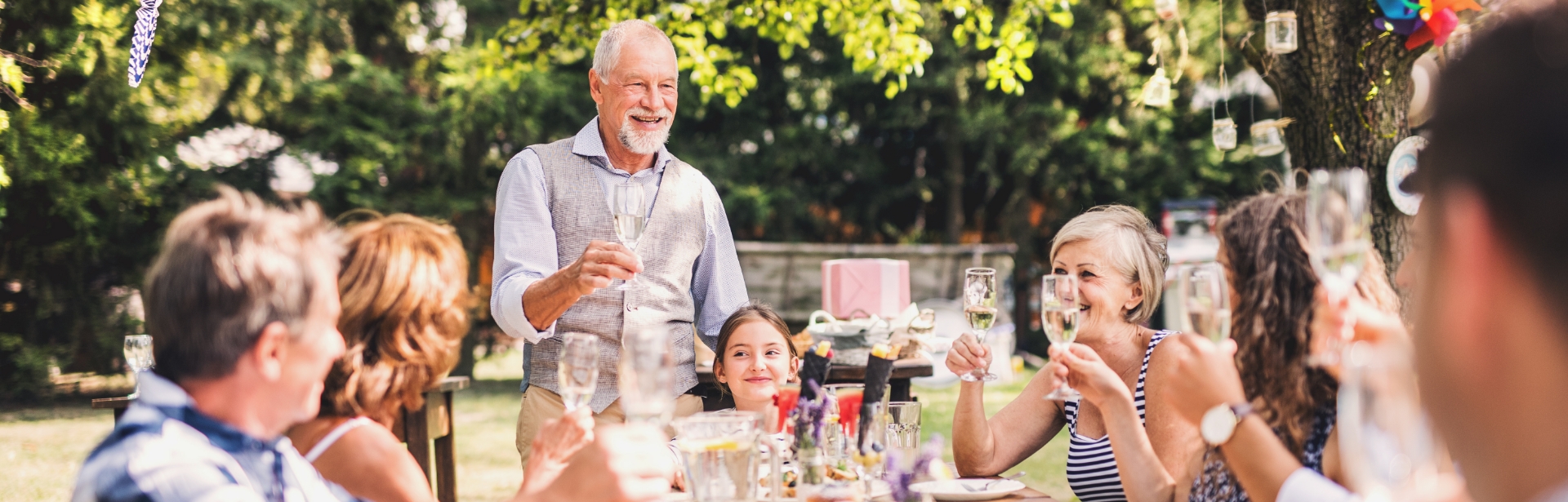 Gruppe Menschen prostet sich zu bei einer Gartenparty